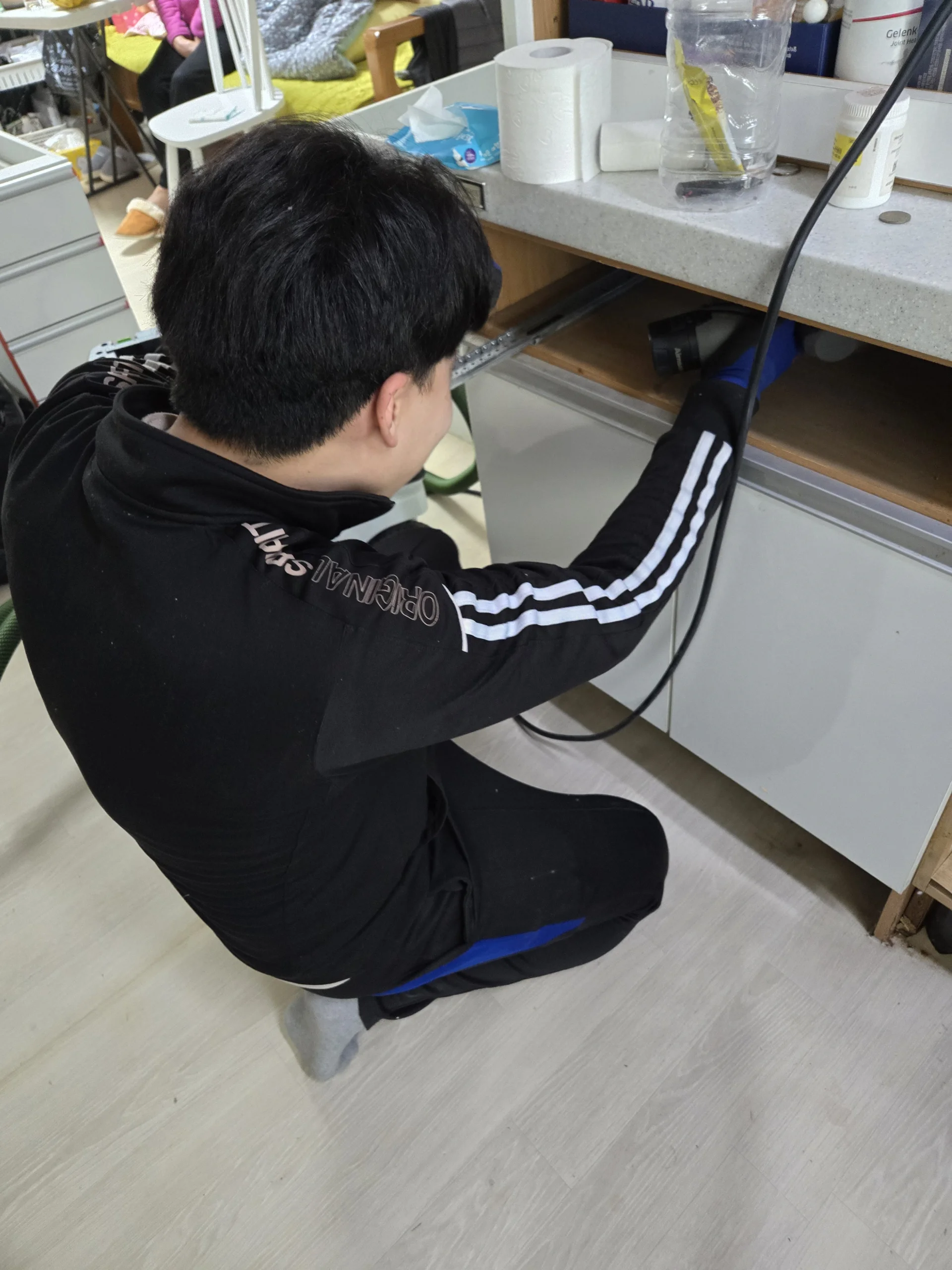 싱크대 수리 교육 바닥에 앉아 하부장 안쪽을 점검하는 실습 실제 수강 사진